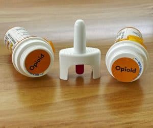 Naloxone spray between two bottles of opioids